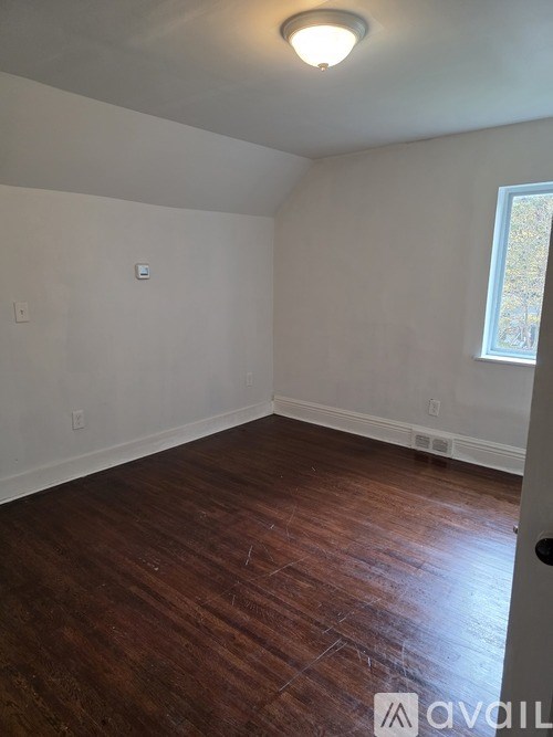 A room with wooden floors and a window.