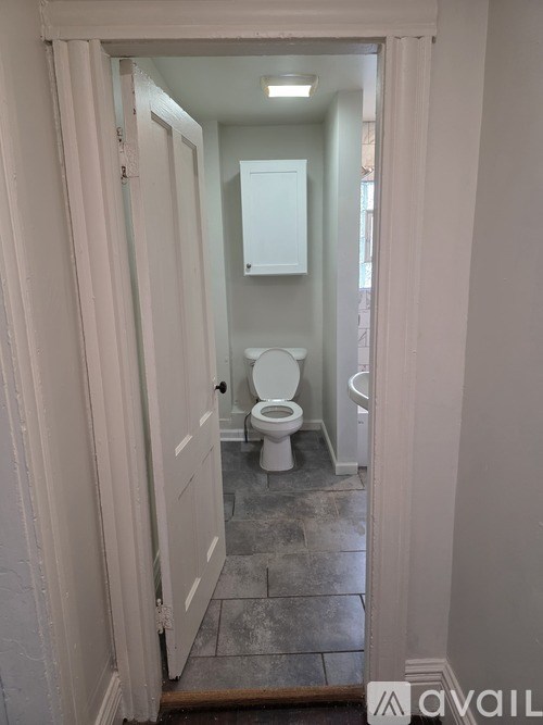 A bathroom with a toilet and a mirror.