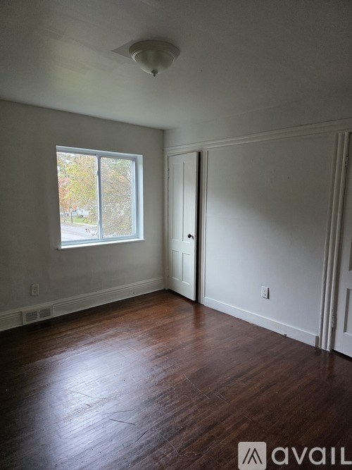 A room with a window and wooden floors.