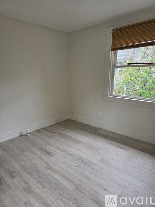 A room with a window and wooden flooring.
