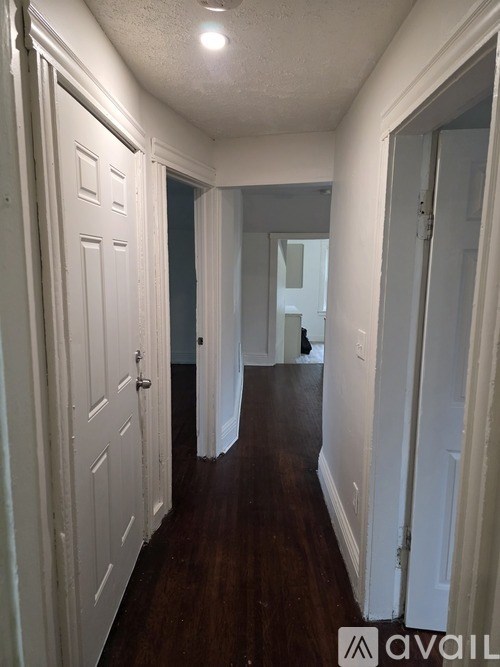A hallway with white doors and a wooden floor.