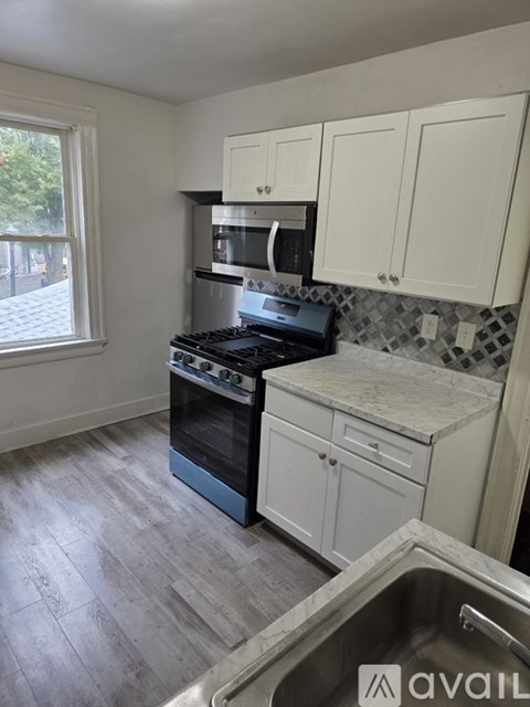 A kitchen with a stove top oven and a microwave above the stove.