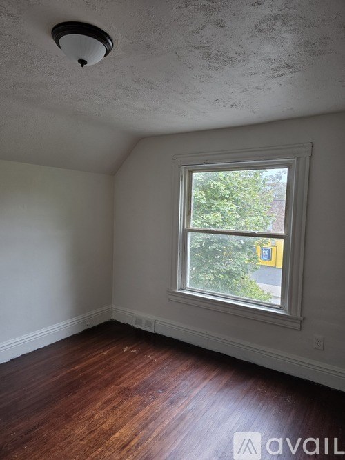 A room with a window and wooden floors.