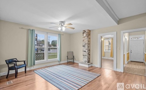 A living room with a blue chair and a striped rug.