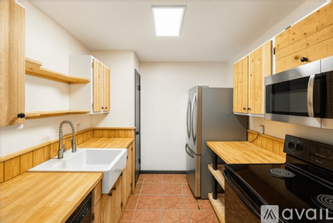 A kitchen with wooden cabinets and a black stove top oven.