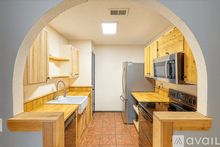 A kitchen with wooden cabinets and a refrigerator.