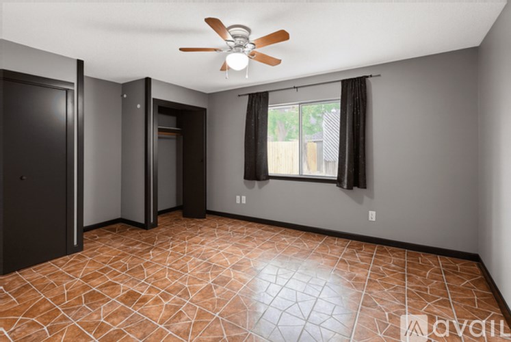A room with a ceiling fan and tile flooring.
