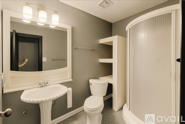 A bathroom with a toilet, sink, and mirror.