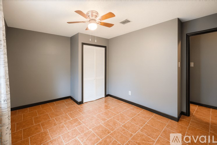 A room with a ceiling fan and tile flooring.