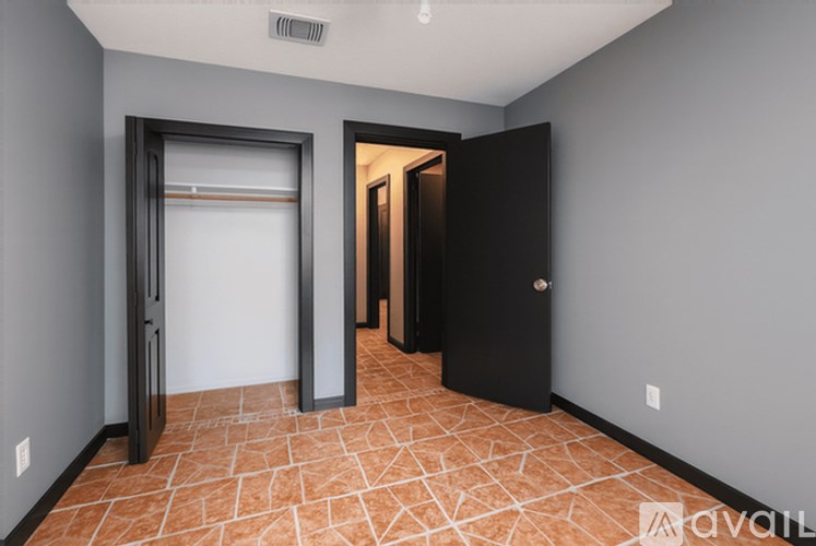 A room with a black door and a tiled floor.