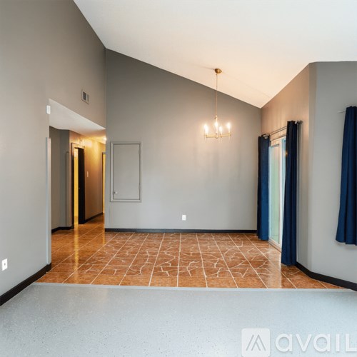A room with a tiled floor and a chandelier hanging from the ceiling.