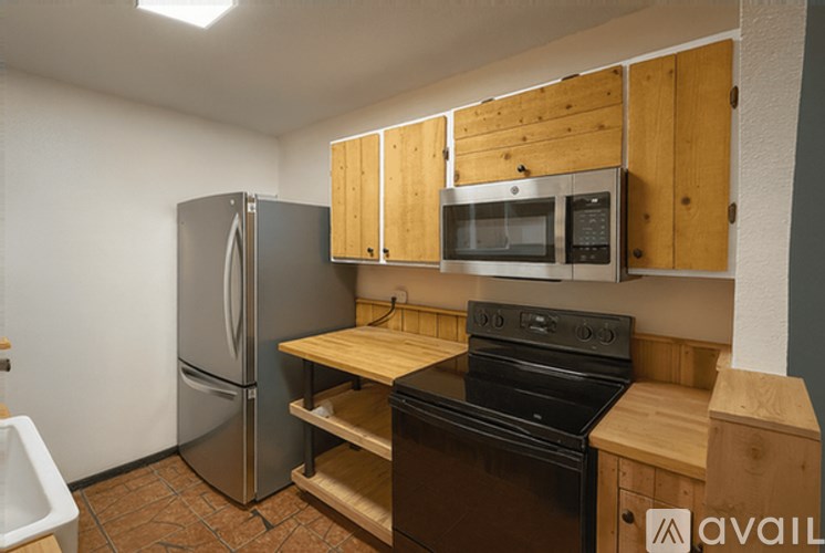 A kitchen with wooden cabinets and a stainless steel refrigerator.