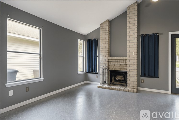 A spacious living room with a fireplace and large windows.