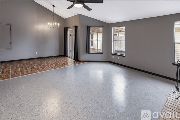A spacious room with a ceiling fan and tiled floor.