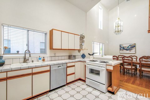 A kitchen with white cabinets and a white stove top oven.