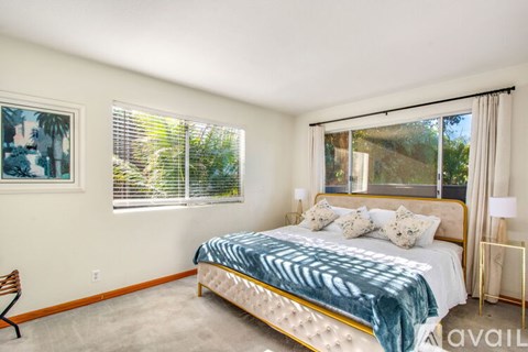 A bedroom with a large bed and a painting on the wall.
