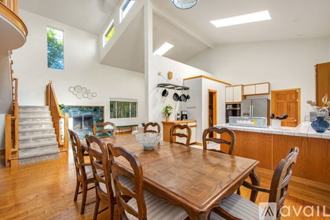 A dining room with a wooden table and chairs.