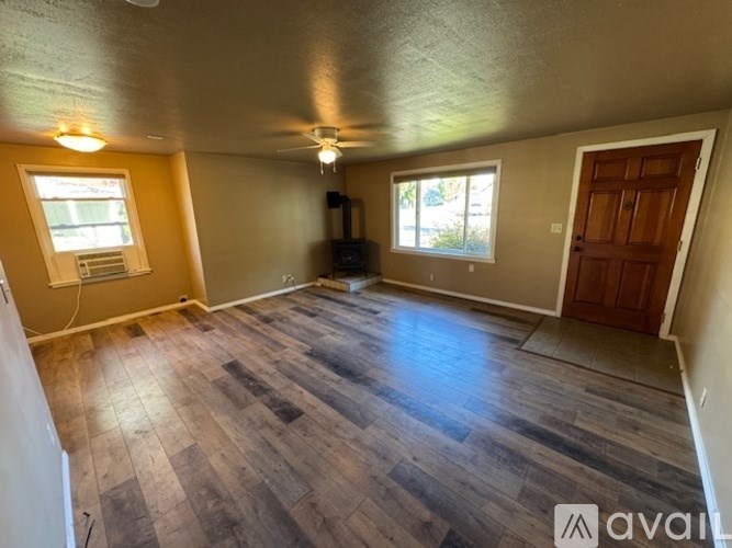 A room with wooden flooring and a ceiling fan.