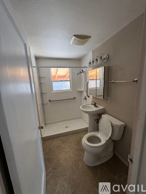 A bathroom with a toilet, sink, and shower.
