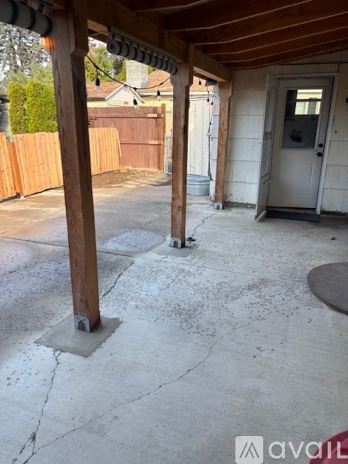 A patio with a white door and a wooden pillar.