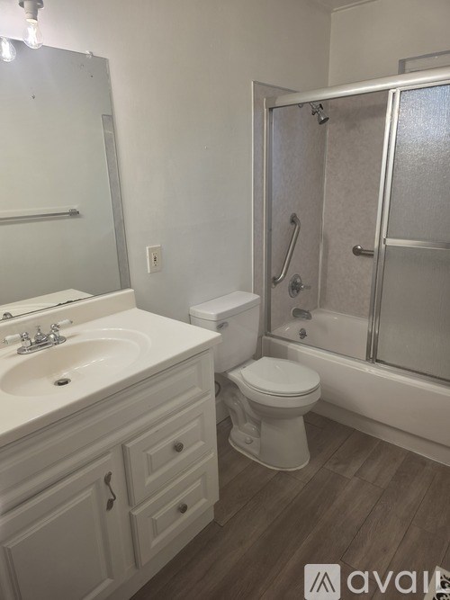 A bathroom with a toilet, sink, and shower.