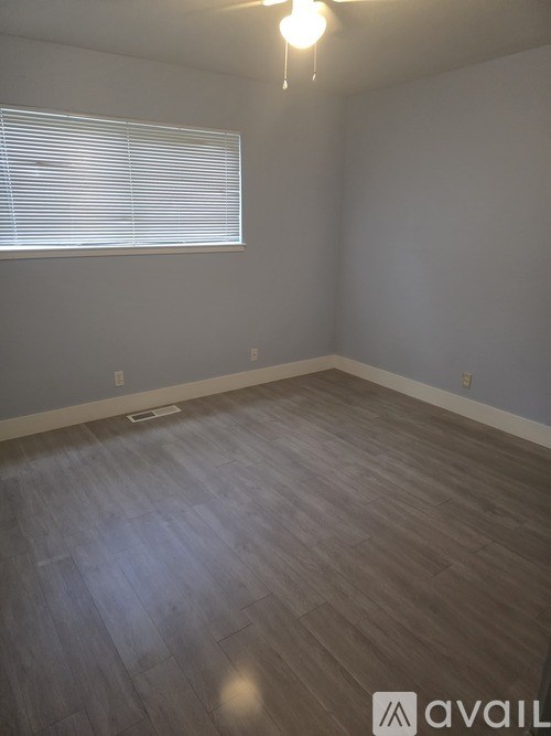 A room with wooden flooring and a ceiling fan.