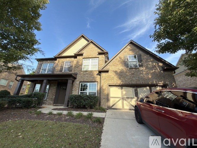 A house with a red car parked in front.
