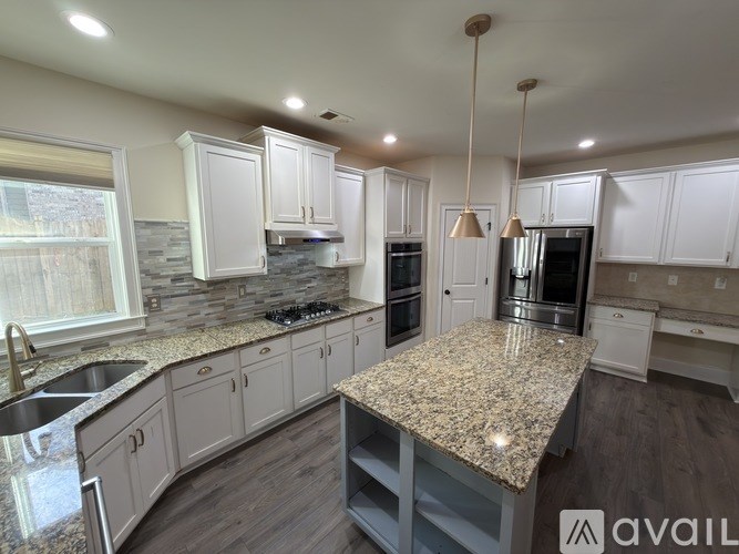 A kitchen with granite countertops and stainless steel appliances.