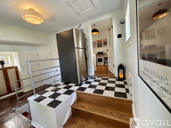A black and white checkered floor in a room with a refrigerator.