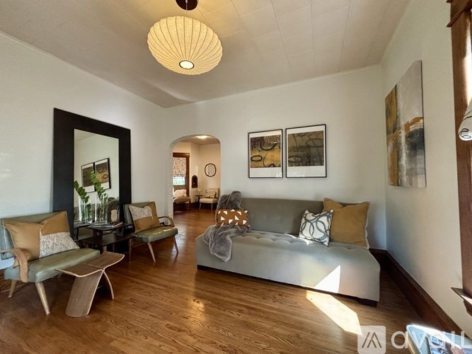 A living room with a grey couch and a wooden floor.