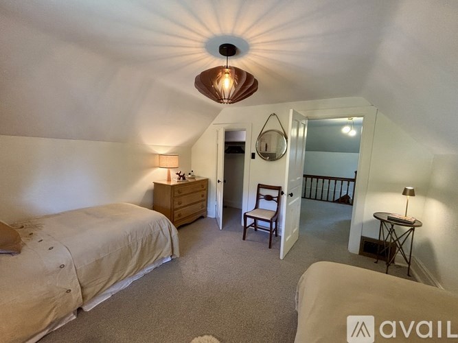 A bedroom with a bed, a chair, and a lamp.