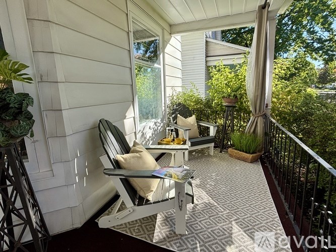 A patio with a white chair and a table with a plant on it.
