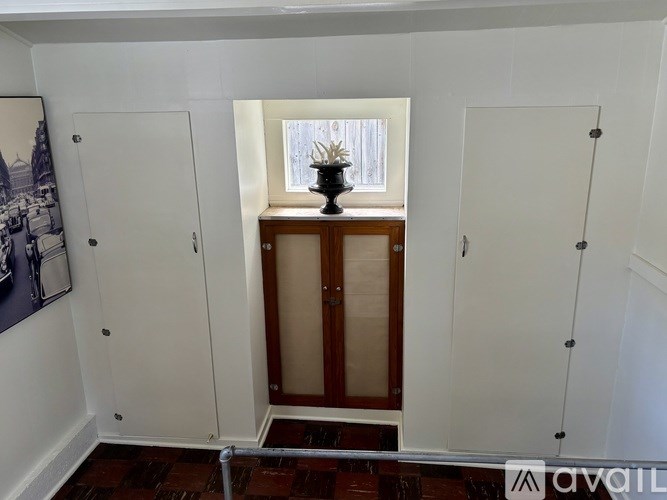 A room with a wooden cabinet and a vase on top of it.