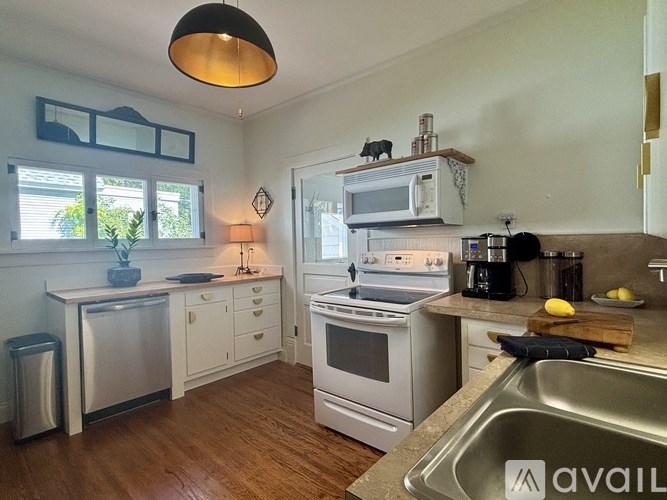 A kitchen with a sink, stove, and oven.