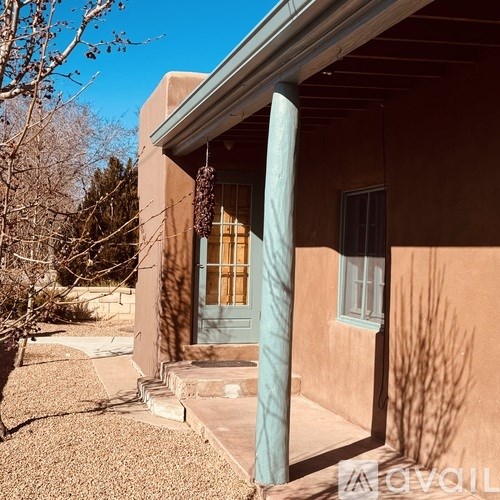 A house with a blue column and a green door.