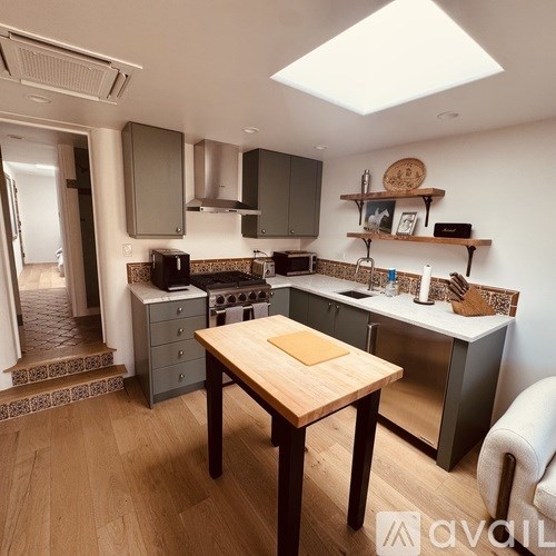 A kitchen with a table and a stove top oven.