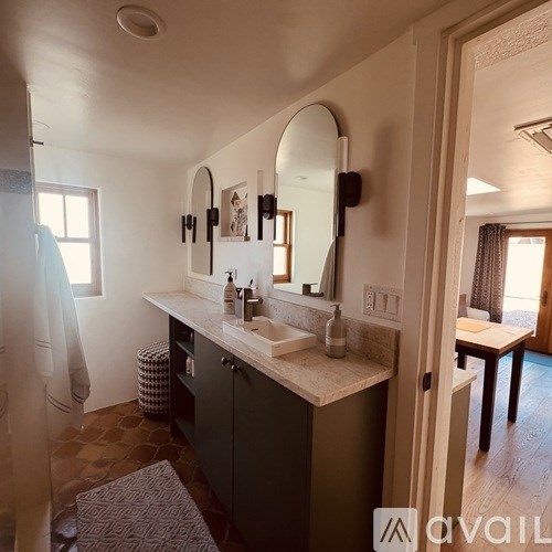 A bathroom with a sink, mirror, and a shower curtain.