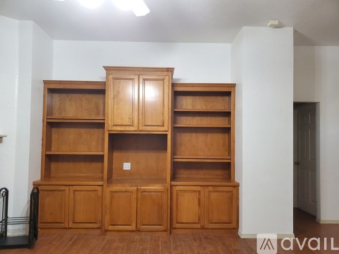 A large wooden bookshelf with a black staircase on the left side.