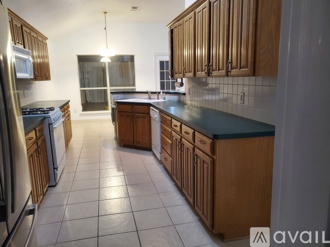 A kitchen with wooden cabinets and a black countertop.