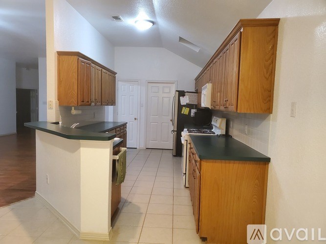 A kitchen with wooden cabinets and a black countertop.