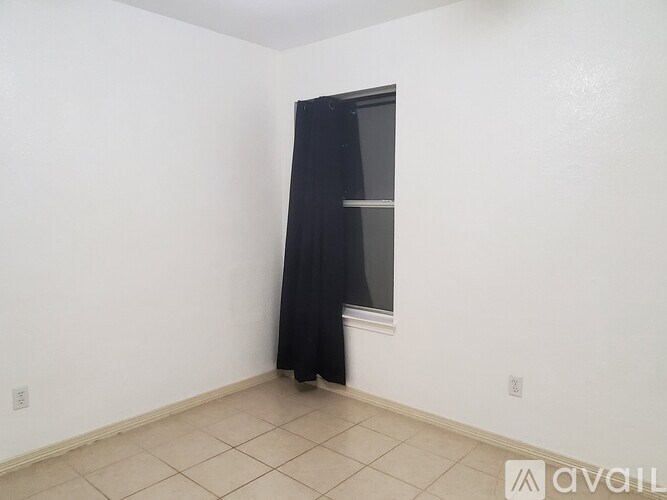 A room with a black curtain and a window.