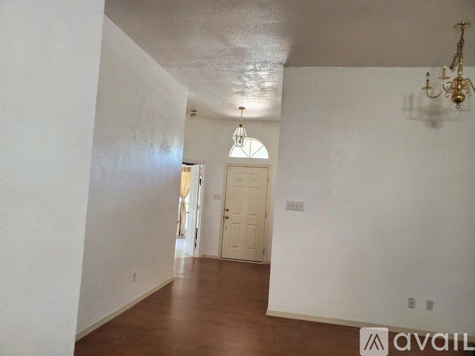 A room with a door and a chandelier.