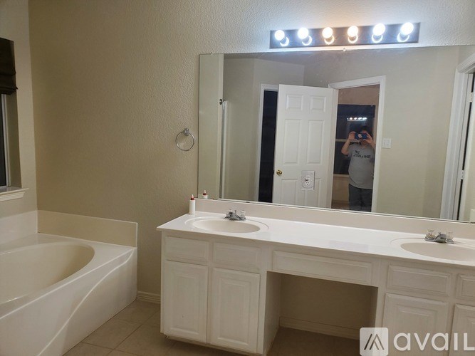 A bathroom with a white vanity and a bathtub.
