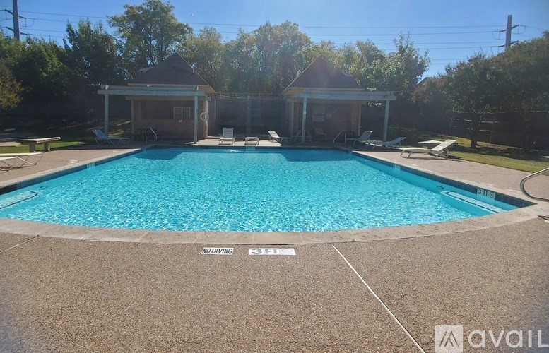 A swimming pool with a tiled edge and a diving board.