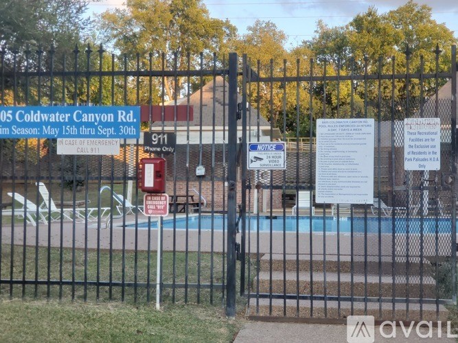 A pool surrounded by a black fence with a sign that says "Coldwater Canyon Rd.".