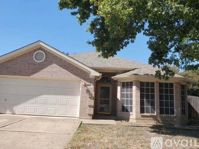 A house with a white garage door and a brown roof.