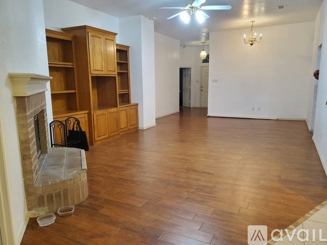 A living room with a fireplace and wooden floors.