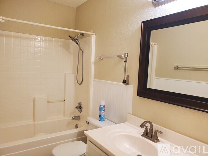 A bathroom with a white toilet, sink, and shower.