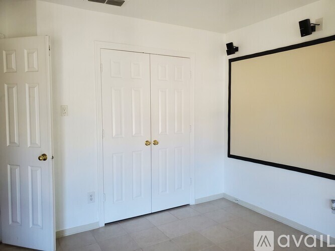 A room with two doors and a large empty wall.