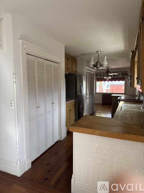 A kitchen with a white cabinet and a wooden counter.